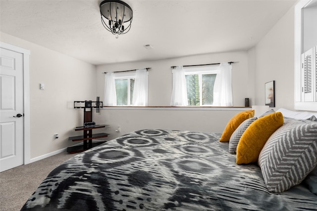 bedroom with carpet floors, a notable chandelier, and baseboards