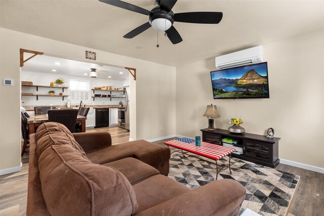 living room with ceiling fan, light hardwood / wood-style floors, and a wall mounted AC