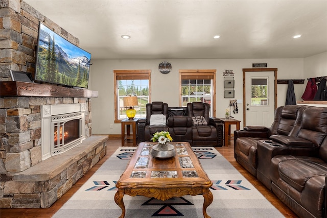 living area featuring a fireplace, baseboards, wood finished floors, and recessed lighting