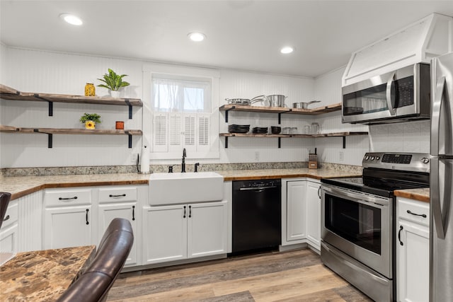 kitchen featuring white cabinets, sink, light wood-type flooring, and stainless steel appliances