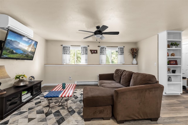 living room with ceiling fan, a baseboard radiator, a wall unit AC, wood finished floors, and baseboards