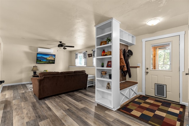 mudroom with dark hardwood / wood-style floors, ceiling fan, and a wall unit AC