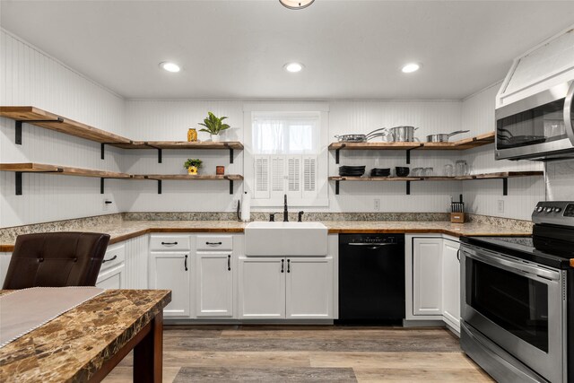 kitchen featuring appliances with stainless steel finishes, light hardwood / wood-style floors, white cabinetry, and sink