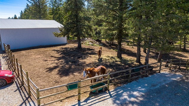 view of yard featuring an outbuilding, an outdoor structure, and fence