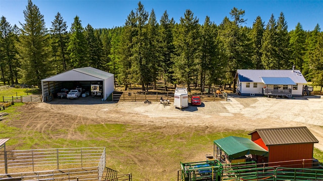 exterior space with a forest view, a rural view, an outbuilding, a pole building, and a carport