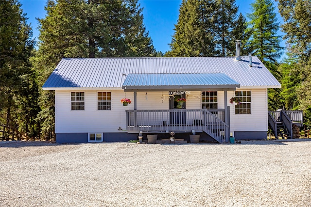 ranch-style house featuring covered porch and metal roof