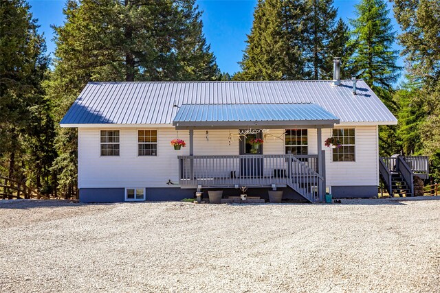 1200 Lost Creek Dr, Kalispell, MT 59901 - view of front of property featuring metal roof, stairway, and covered porch