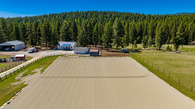 drone / aerial view featuring a view of trees and a rural view