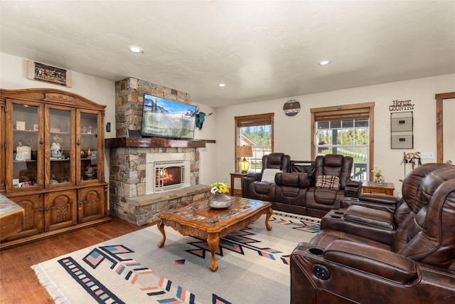 living area with recessed lighting, wood finished floors, and a fireplace