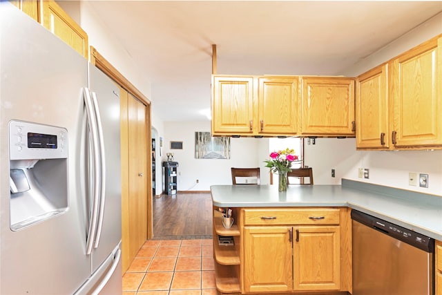 kitchen featuring kitchen peninsula, light tile flooring, and appliances with stainless steel finishes