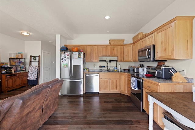 kitchen featuring appliances with stainless steel finishes, sink, light brown cabinetry, and dark hardwood / wood-style floors