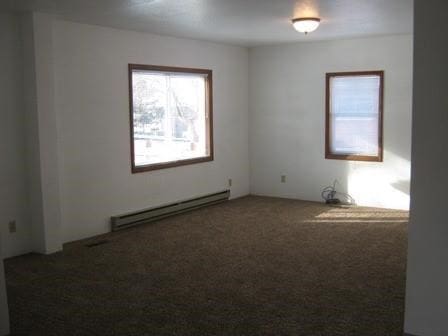 carpeted spare room with baseboard heating