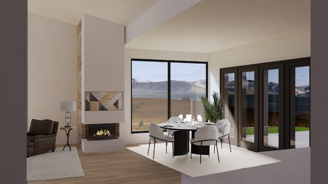 dining space with a mountain view, a fireplace, and hardwood / wood-style flooring