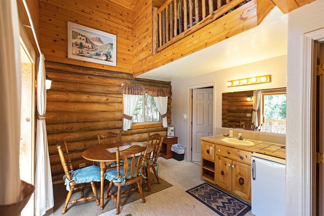 283 Lost Trail Hot Springs Rd, Sula, MT 59871 - carpeted dining area featuring a wealth of natural light, sink, rustic walls, and a high ceiling