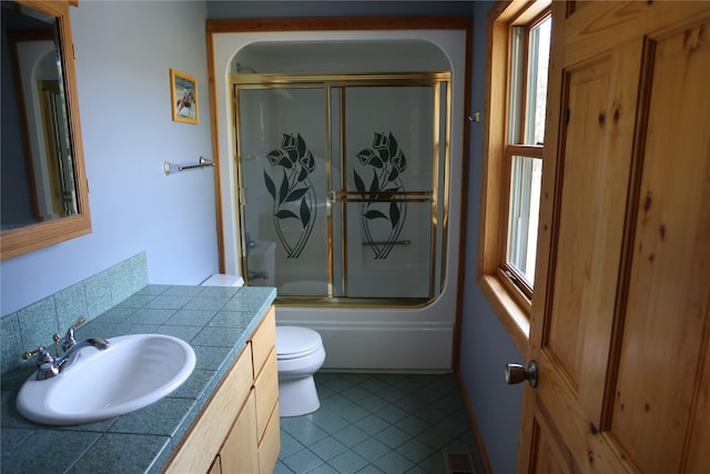 41698 Canal Rd, Polson, MT 59860 - bathroom with toilet, vanity, tile patterned floors, and shower / bath combination with glass door