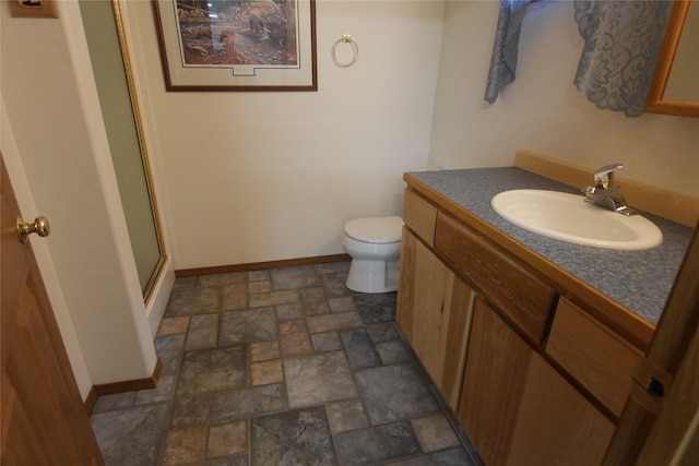 41698 Canal Rd, Polson, MT 59860 - bathroom with stone finish flooring, vanity, toilet, an enclosed shower, and baseboards