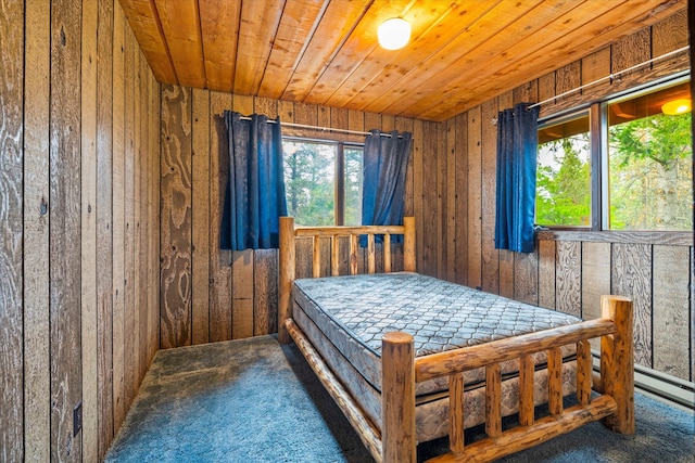 bedroom featuring wooden walls, dark colored carpet, and wood ceiling