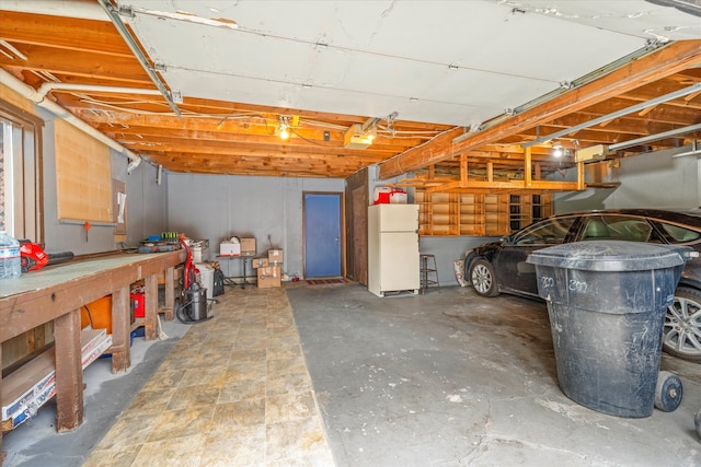 basement featuring a workshop area and white fridge