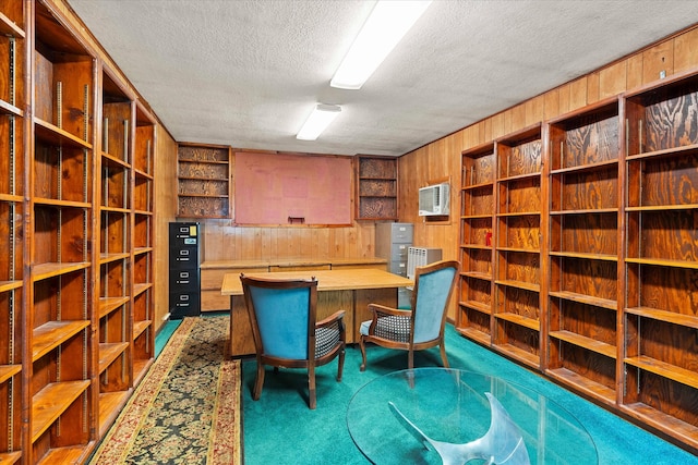 office area featuring a wall unit AC, wood walls, a textured ceiling, and carpet flooring