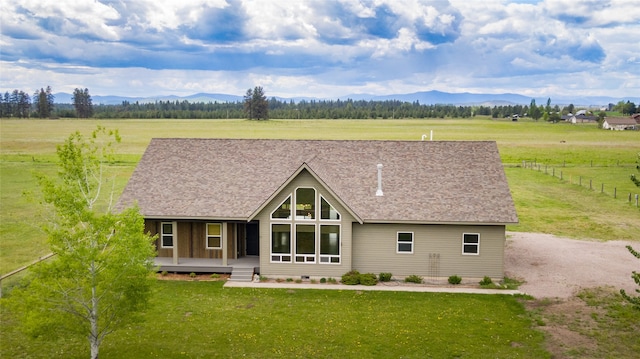 rear view of house featuring a lawn, a mountain view, and a porch