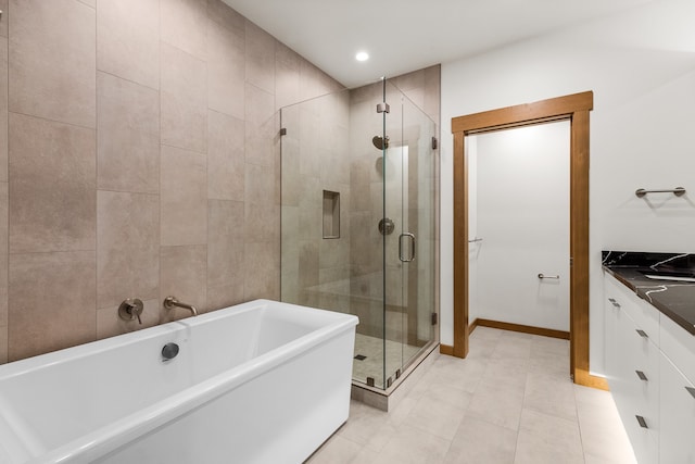 bathroom with tile floors, plus walk in shower, tile walls, and vanity