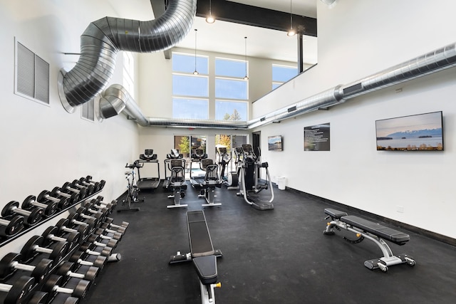 exercise room featuring a towering ceiling