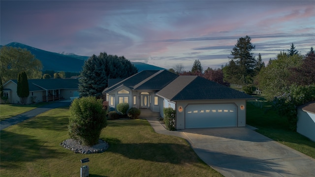 ranch-style house with a garage and a yard