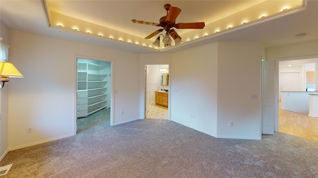 spare room featuring carpet flooring, ceiling fan, and a tray ceiling