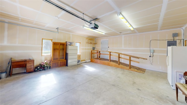 garage featuring white refrigerator and a garage door opener