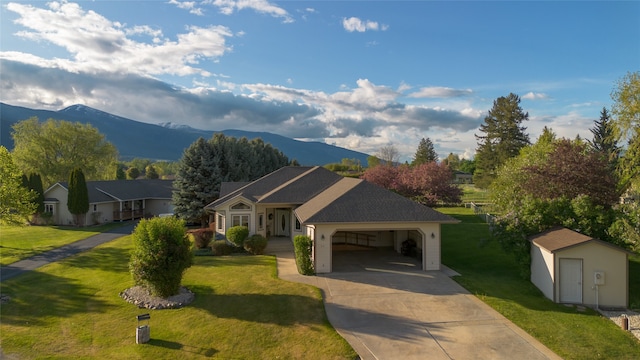 ranch-style house with an outdoor structure, a front yard, a mountain view, and a carport