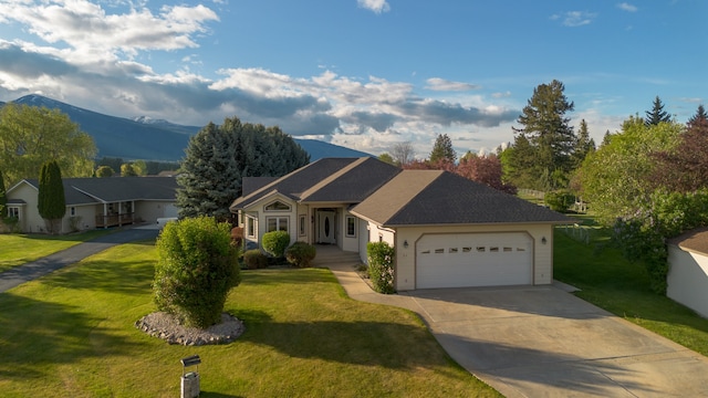 ranch-style home with a front yard, a garage, and a mountain view