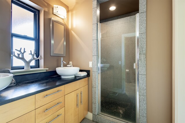 bathroom featuring a shower with door and large vanity