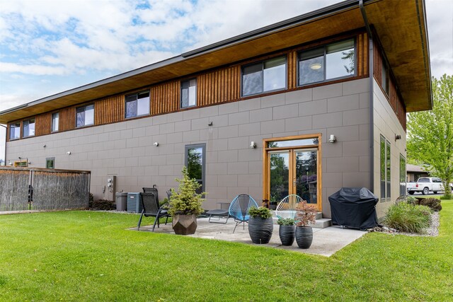 rear view of property featuring a yard and a patio area