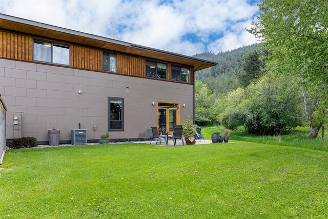 back of house with a patio, central air condition unit, and a yard