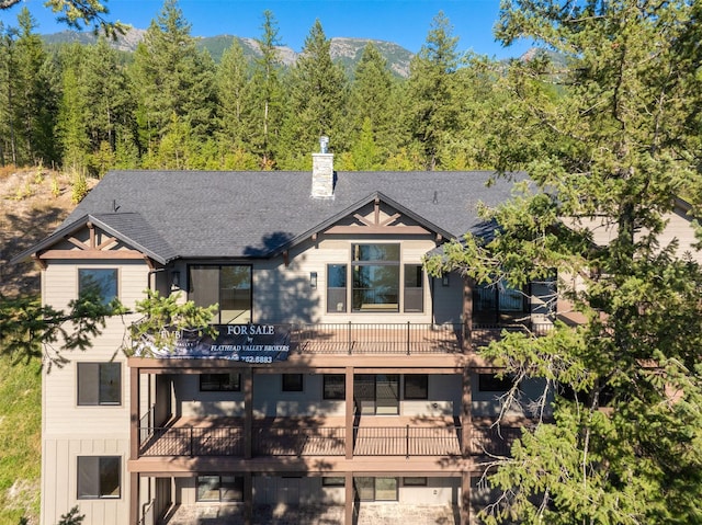 198 Blaine Lakeshore Dr, Kalispell, MT 59901 - view of front of home featuring a mountain view, a chimney, and a shingled roof