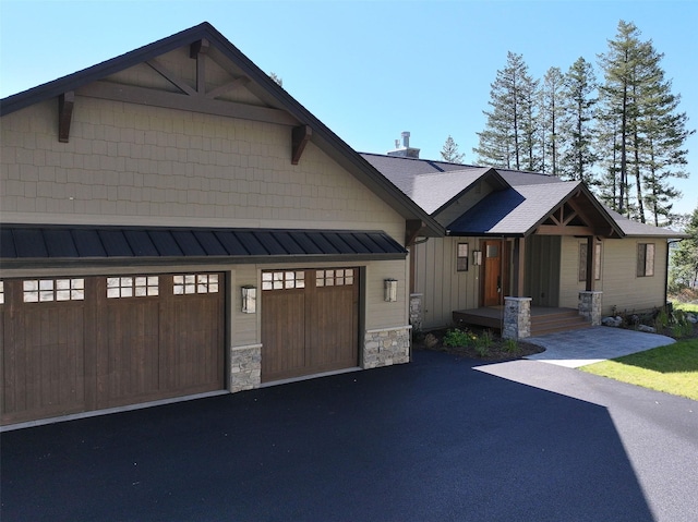198 Blaine Lakeshore Dr, Kalispell, MT 59901 - view of front facade featuring board and batten siding, stone siding, and aphalt driveway
