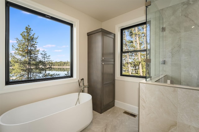 198 Blaine Lakeshore Dr, Kalispell, MT 59901 - full bathroom featuring a tile shower, a soaking tub, visible vents, and a wealth of natural light
