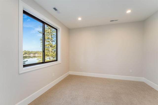 198 Blaine Lakeshore Dr, Kalispell, MT 59901 - spare room featuring light carpet, visible vents, and baseboards