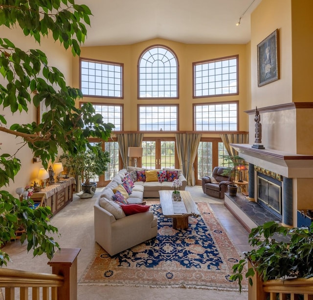 living room with carpet floors, a fireplace, high vaulted ceiling, and rail lighting