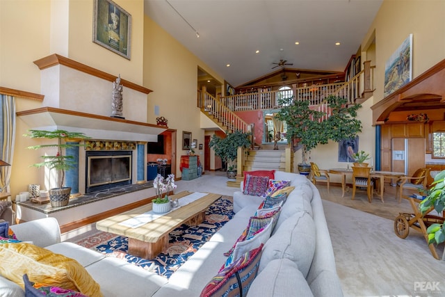 carpeted living room with a towering ceiling and a fireplace