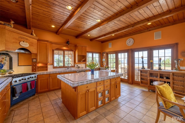 kitchen featuring tasteful backsplash, high end range, a center island, and light tile patterned flooring