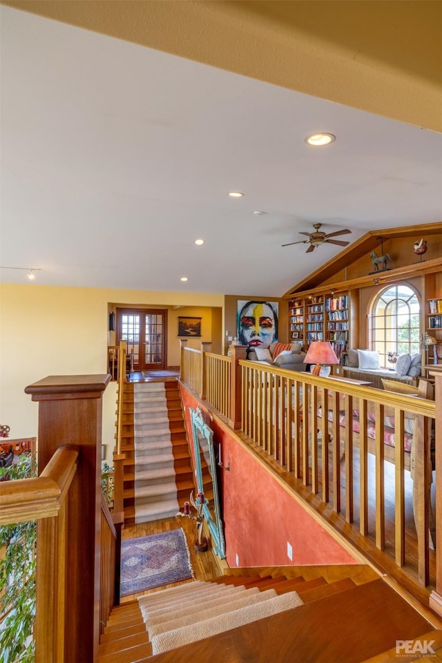 hallway with vaulted ceiling and light wood-type flooring