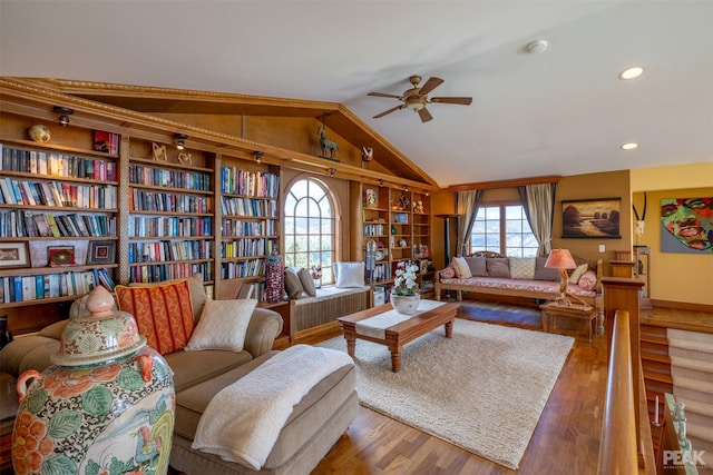 living room with ceiling fan, lofted ceiling, and hardwood / wood-style floors