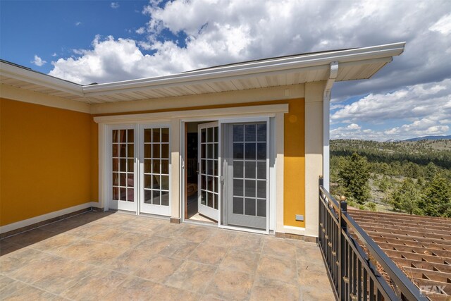 entrance to property with a patio, french doors, and a balcony