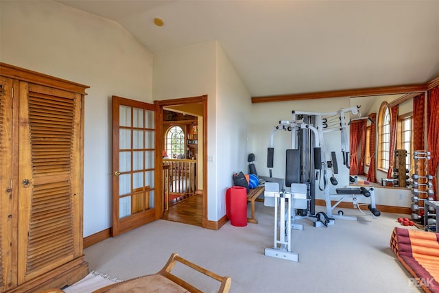 workout area with lofted ceiling and light colored carpet