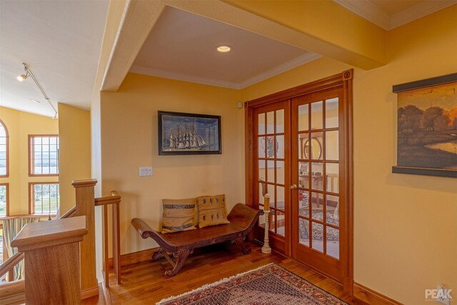 doorway to outside with wood-type flooring, ornamental molding, and french doors