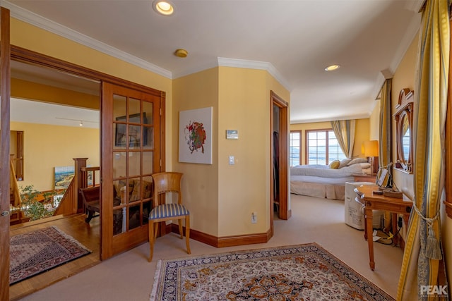 hallway with ornamental molding and light carpet