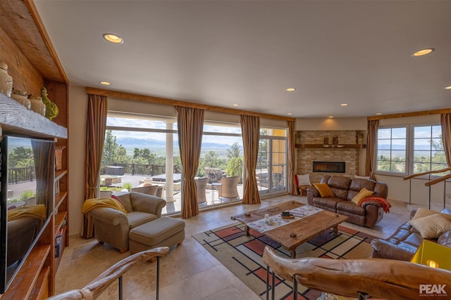 tiled living room featuring a stone fireplace and a healthy amount of sunlight