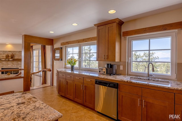 kitchen with sink, tasteful backsplash, light tile patterned floors, dishwasher, and light stone countertops