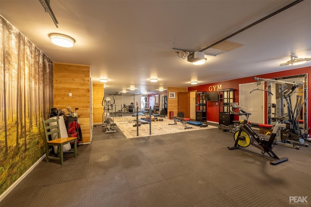 garage featuring a garage door opener and wood walls